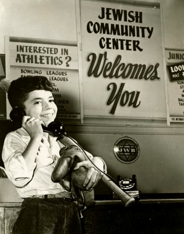 A Jewish Community Center promotional photo, circa 1950, shows a young boy carrying baseball equipment.