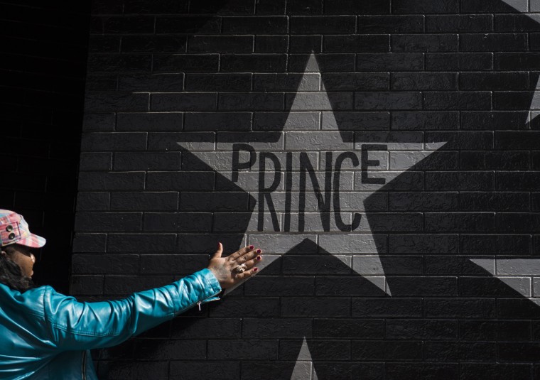 Image: A woman touches the Prince star on the wall outside First Avenue nightclub