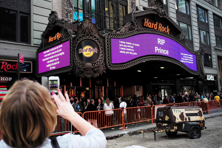 Image: A woman takes a picture of a tribute message in New York