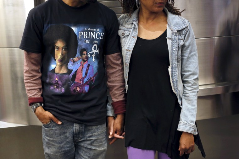 Image: A couple watches as fans gather at Harlem's Apollo Theater in New York