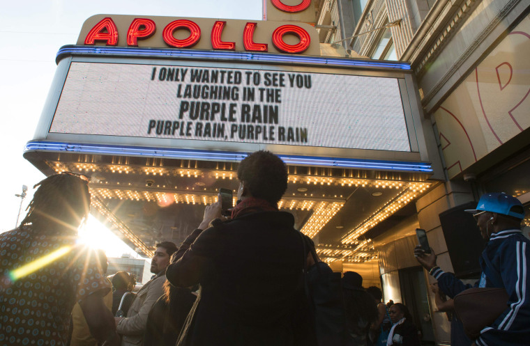 Image: People gather outside the Apollo Theater to listen to music by Prince in New York