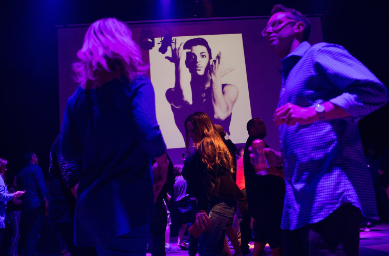 Image: Guests dance to Prince music as a slide show flashes images of the artist during a memorial dance party at the First Avenue nightclub