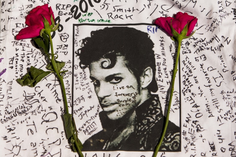 Image: Flowers lay on a T-shirt signed by fans of singer Prince