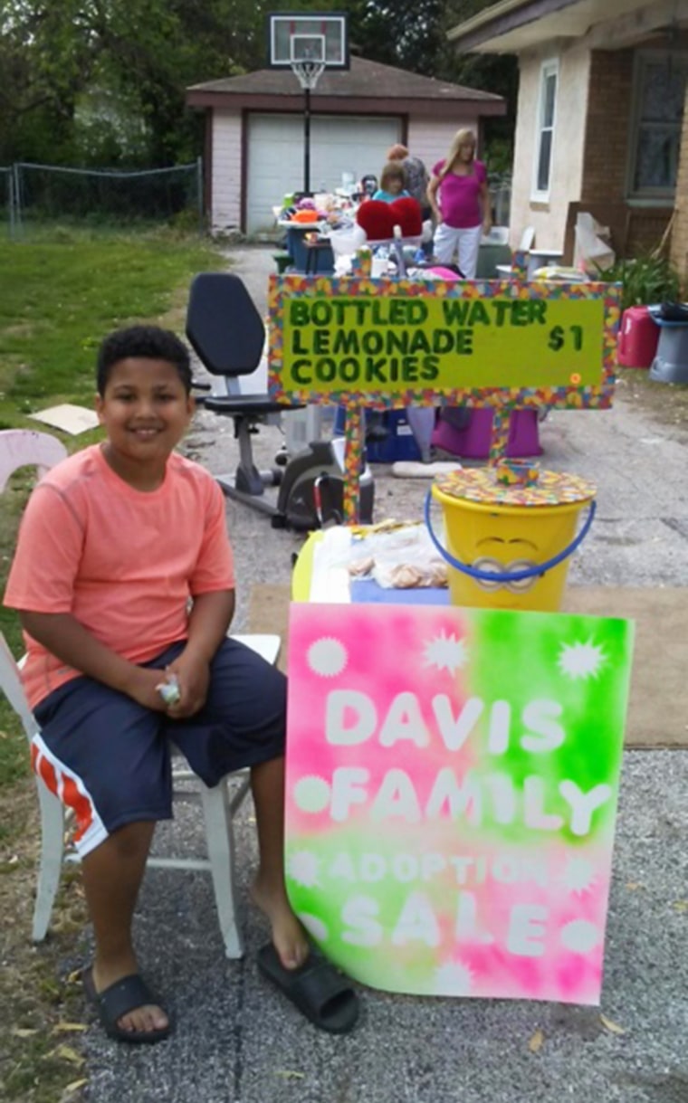 Tristan Jacobson selling lemonade at a yard sale to raise money to help the Davis family formally adopt him.