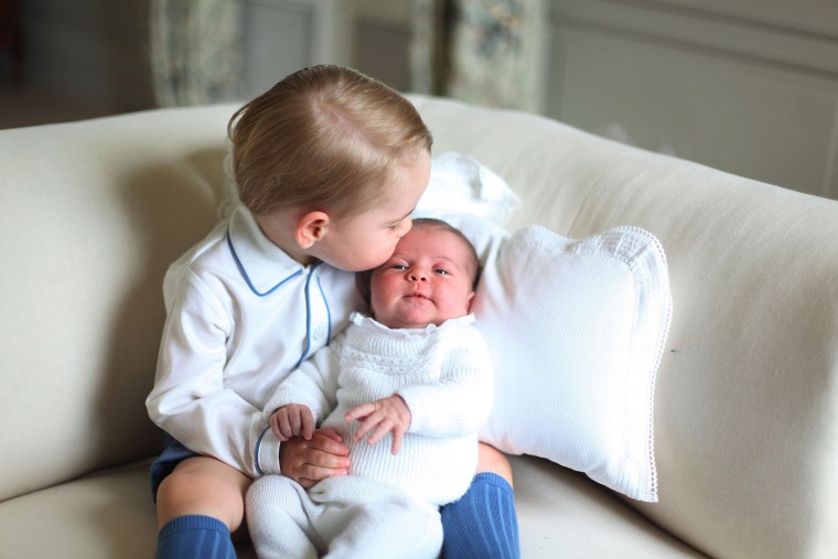 Prince George kissing the top of Princess Charlotte's head