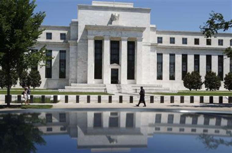 File image of the U.S. Federal Reserve is reflected in car as security officer patrols front of building in Washington
