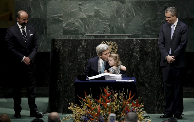 Image: U.S. Secretary of State Kerry holds his granddaughter as he signs the Paris Agreement on climate change at United Nations Headquarters in New York