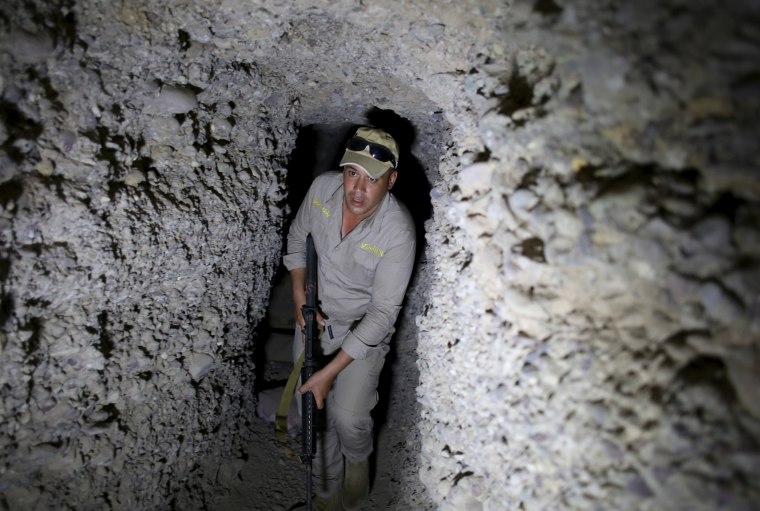 Image: An Iraqi soldier holds his rifle in an underground tunnel built by Islamic State fighters in a village of Har Bardun