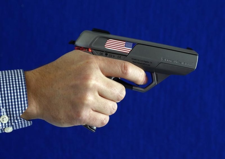 An Armatix employee holds a smart gun by the company at the Armatix headquarters in Munich