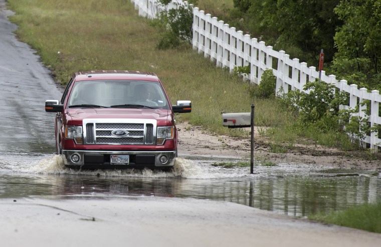 A man drives through floodwaters near the Ozarka Wood County Bottling Plant in Hawkins, Texas, on April 30, 2016. The Ozarka Plant's roof was reported damaged and trucks were reportedly overturned in their parking lot.