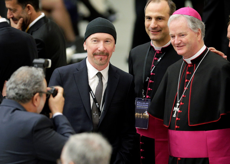 Image: U2 guitarist David Evans poses with Irish bishop Paul Tighe.