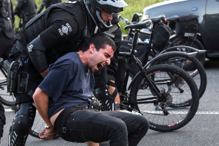 Image: Police detain a protester during anti-capitalist protests following May Day marches in Seattle