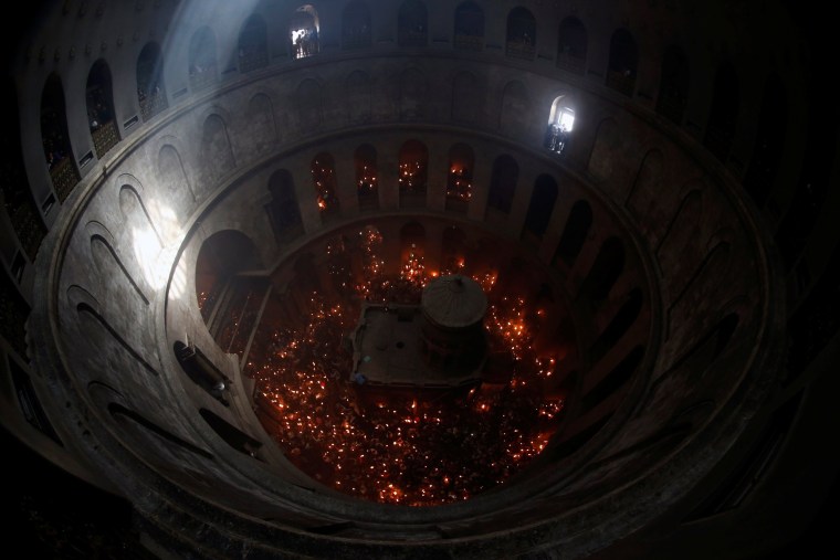 Image: Worshippers hold candles as they part in the "Holy Fire" ceremony