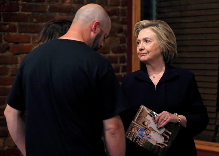 Image: U.S. Democratic presidential candidate Hillary Clinton speaks to Bo Copley about a photograph of his children during a campaign event in Williamson