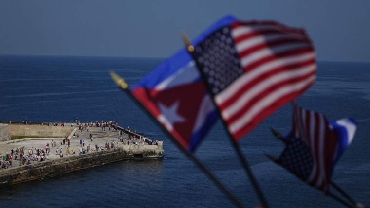 Image: Passengers on board Carnival's Adonia cruise ship wave flags as they arrive from Miami in Havana