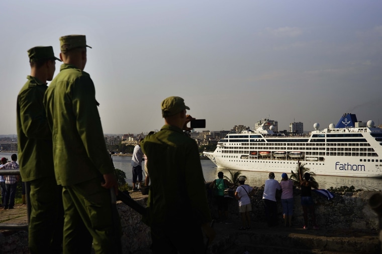 Image: Cuban soldiers watch the Carnival Adonia cruise ship arrive from Miami