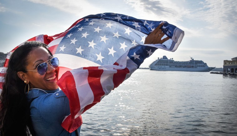 Image: A Cuban waves a US flag at the Malecon waterfront