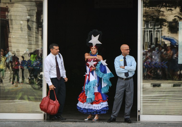 Image: A dancer with the welcoming commission waits at the entrance of the cruise terminal in Havana