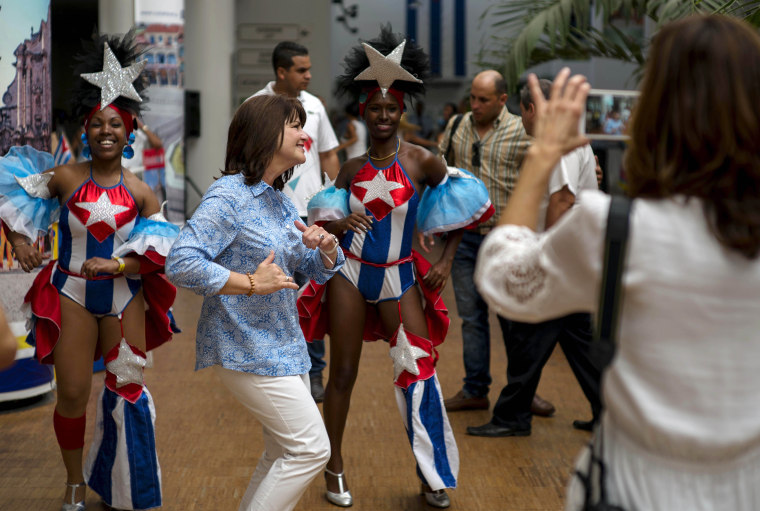 Image: A cruise passenger dances with a couple of Cuban entertainers