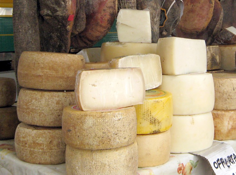 Cheese and ham on display at a market in Sardinian Olbia, Italy.