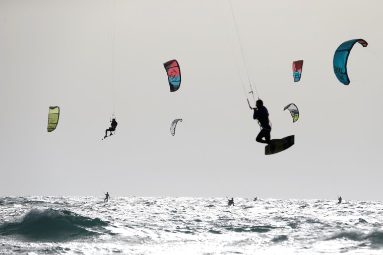 Image: People kitesurf in the Mediterranean sea in Tel Aviv