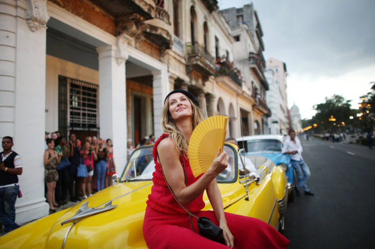 Image: Brazilian top model Gisele Bundchen poses before a fashion show by German designer Karl Lagerfeld as part of his latest inter-seasonal Cruise collection for fashion house Chanel at the Paseo del Prado street in Havana, Cuba