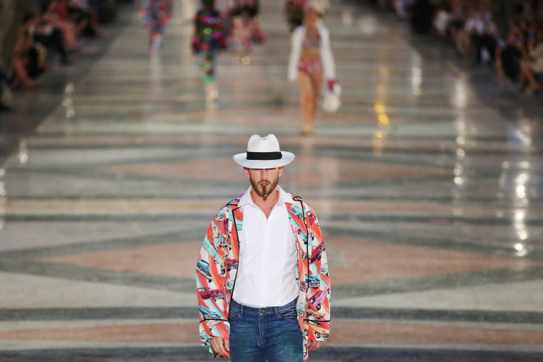 Image: A model smokes a cigar as he presents a creation by German designer Karl Lagerfeld as part of his latest inter-seasonal Cruise collection for fashion house Chanel at the Paseo del Prado street in Havana, Cuba