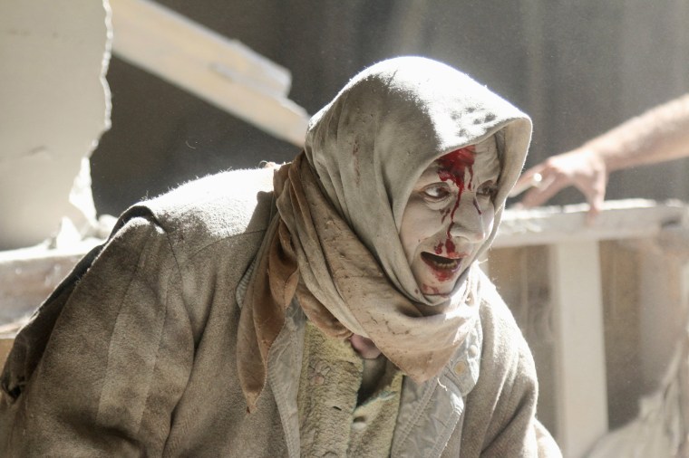 Image: An injured woman reacts at a site hit by airstrikes in the rebel held area of Old Aleppo