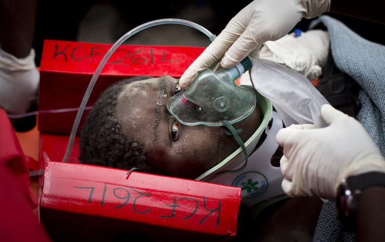 Image: A woman is carried away in a stretcher by medics as she is rescued after being trapped for six days