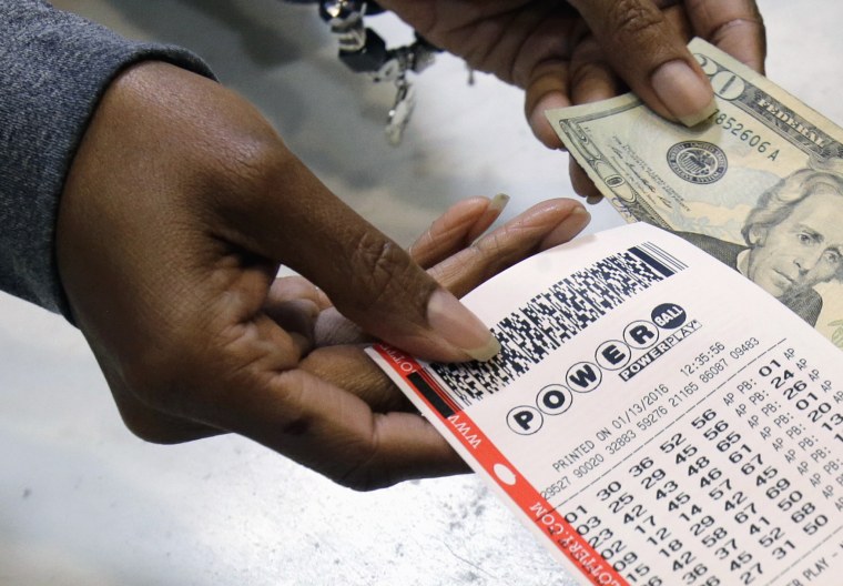 FILE - In this Jan. 13, 2016 file photo, a clerk hands over a Powerball ticket for cash at Tower City Lottery Stop in Cleveland. Powerball estimates that its jackpot for the May 4, 2016, drawing is $348 million. (AP Photo/Tony Dejak, File)
