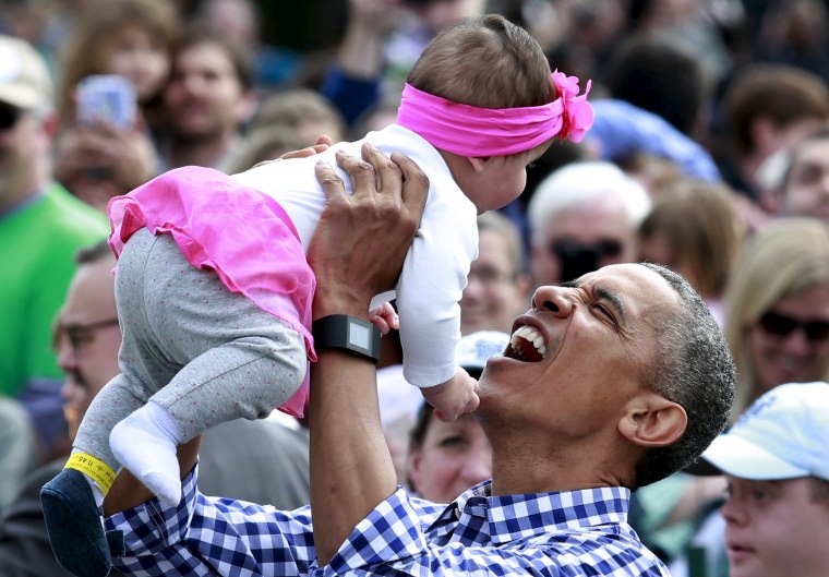 Image: President Barack Obama holds a baby during the 2016 White House Easter Egg Roll on the South Lawn