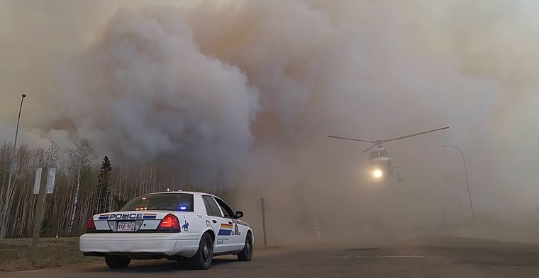 Image: A helicopter is seen through heavy smoke