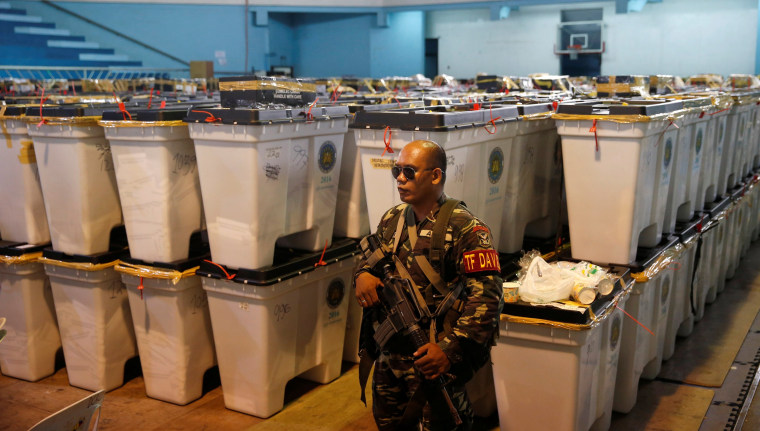 Image: A soldier guards boxes containing election ballots and other paraphernalia in Davao city