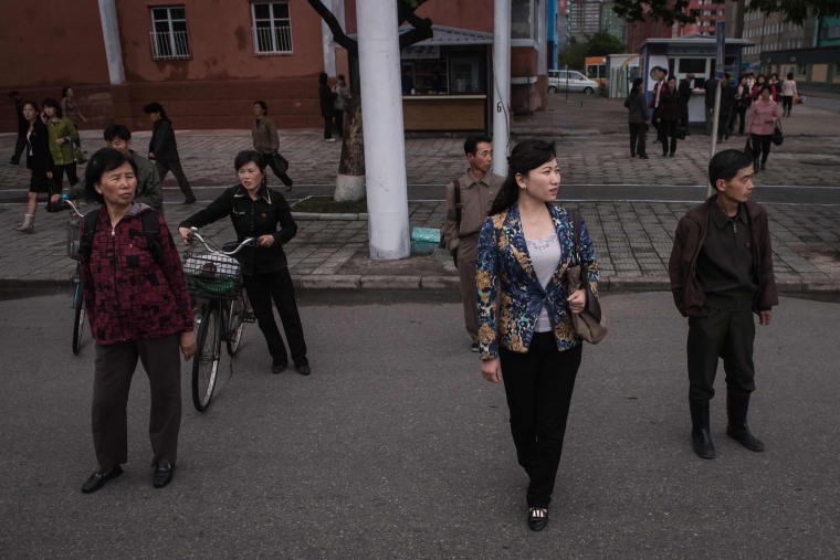 Image: Pedestrians wait to cross a street in Pyongyang on