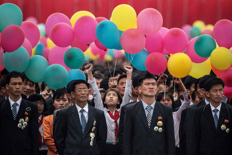 Image: Participants wait to take part in a mass parade marking the end of the 7th Workers Party Congress