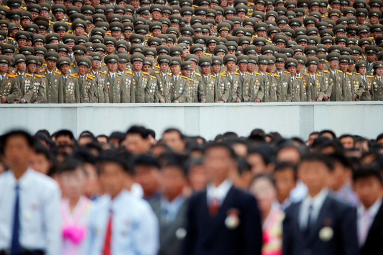 Image: Military officials stand above other participants during a mass rally and parade in Pyongyang