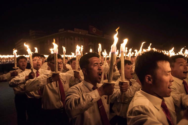 Image: Performers take part in a torchlight parade on Kim Il-Sung square