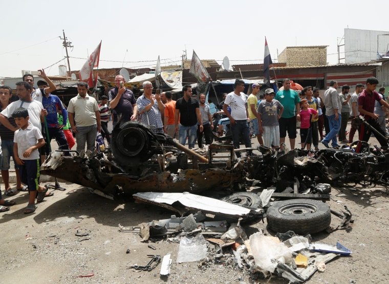 Image: People gather at the scene of a car bomb attack in Baghdad