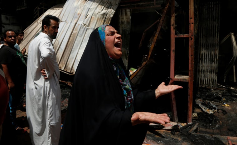 Image: A woman reacts at the scene of a car bomb attack in Baghdad