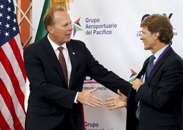 Image: San Diego Mayor Faulconer shakes hands with Mexico's Secretary of Tourism de la Madrid Cordero during the official opening of a privately funded cross border pedestrian bridge that connects the United States with Tijuana International Airport, in O