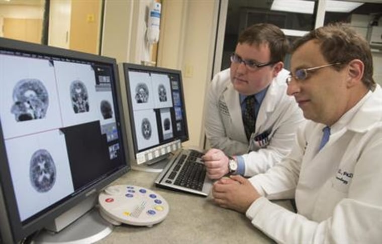 Associate professor of neurology at Washington University School of Medicine Beau Ances MD, PhD, right, and Matthew Brier an MD/PhD student at the university, examining PET (positron emission tomography) scans of Alzheimer's disease patients, in St. Louis. Scientists are peeking inside living brains to watch for the first time as a toxic duo of plaques and tangles interact to drive Alzheimer's disease, with implications for better treatments. (Robert Boston/Washington University via AP)