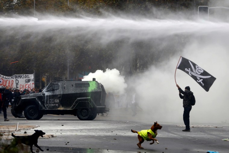 Image: A student clashes with riot police during a demonstration to demand changes in the education system in Santiago