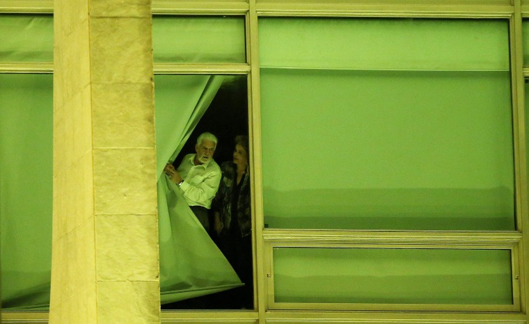 Image: Brazil's President Rousseff and Chief of Staff Wagner look from a window at Planalto Palace in Brasilia