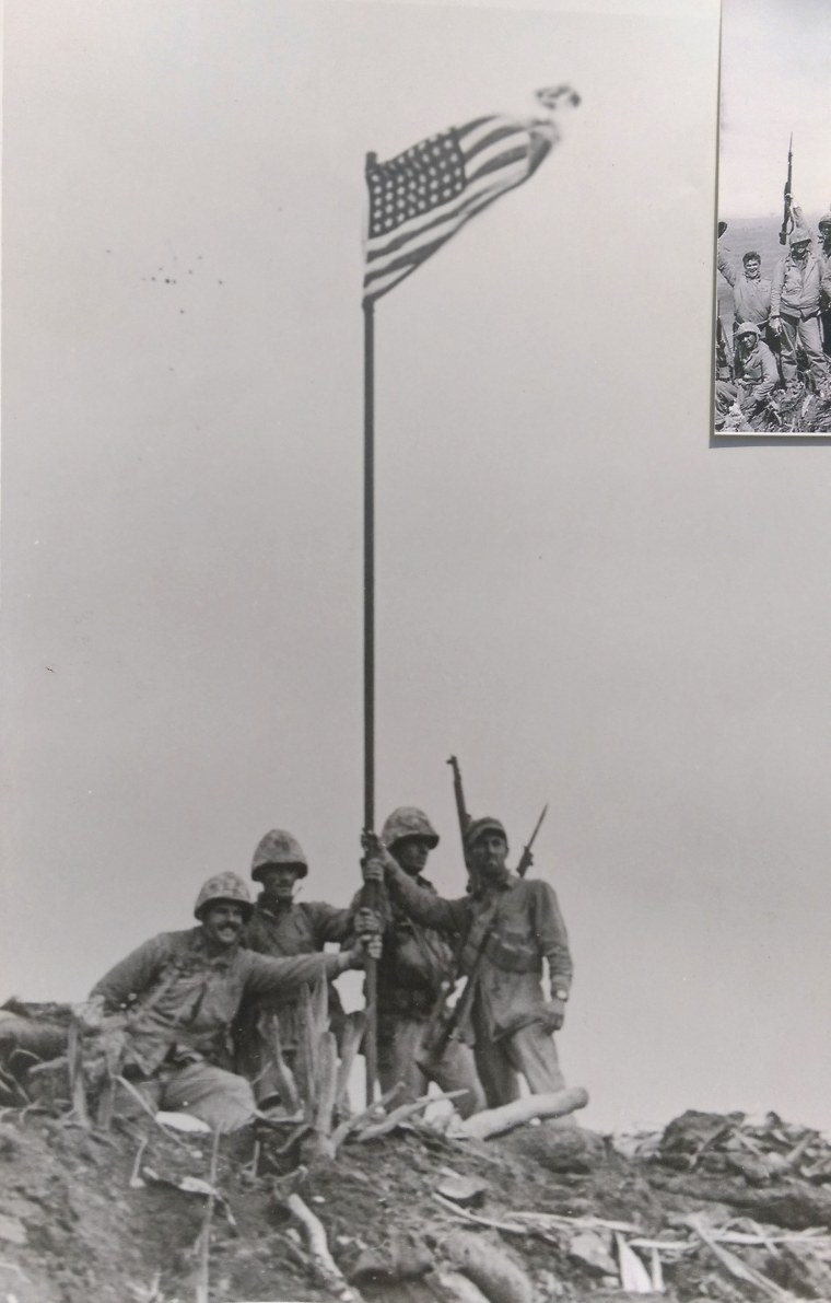 Photo taken by Army Pfc. George Burns shows the first flag flying on Mount Suribachi on Iwo Jima, hours before the raising of the flag captured by AP photographer Joe Rosenthal.