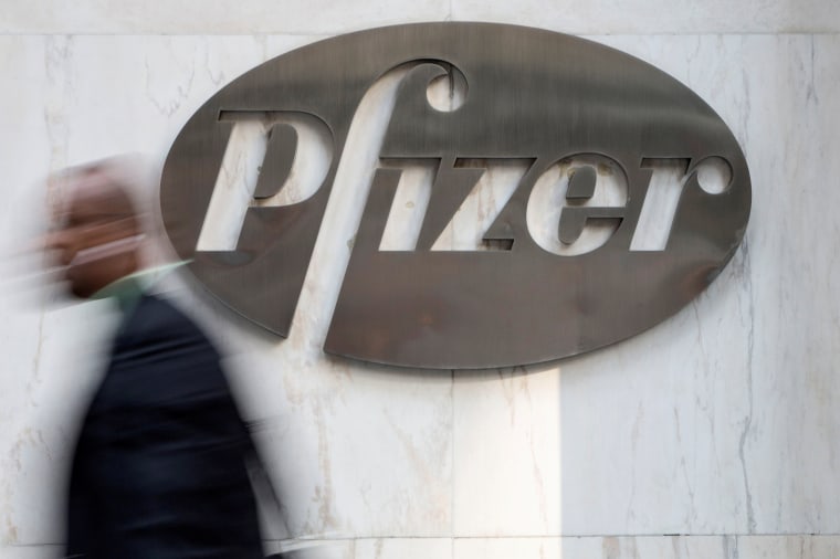 Image: A man walks past Pfizer's world headquarters in New York