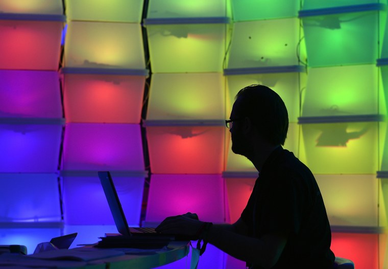 Man at computer surrounded by colorful squares