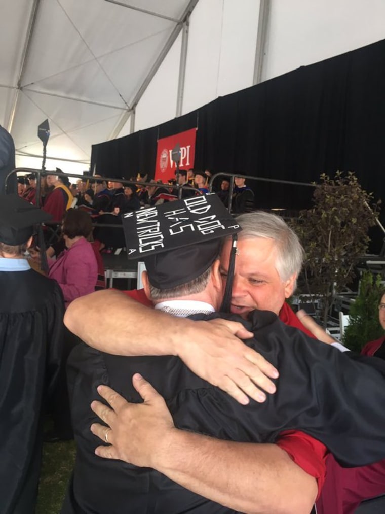 Michael Vaudreuil hugs friend and co-worker Wayne Atchue after graduating.