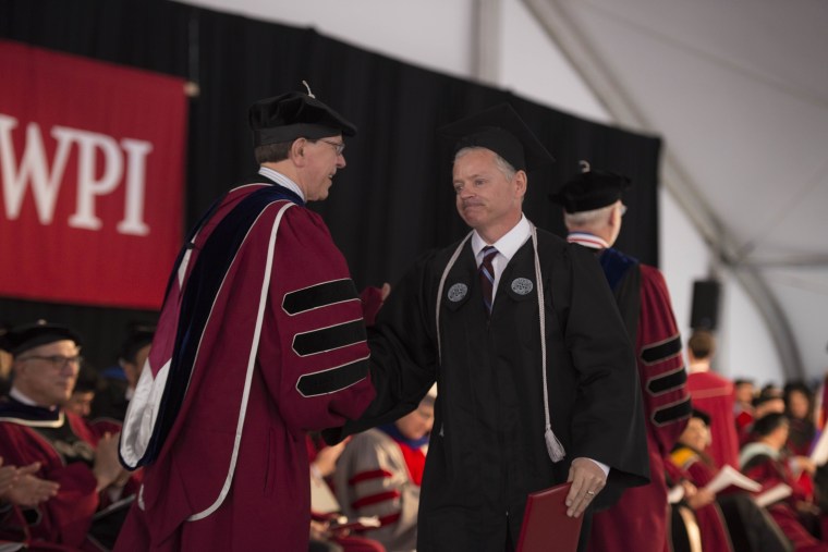Michael Vaudreuil shakes hands with WPI Dean of Engineering David Cyganski after spending the last eight years as a college custodian at night and taking classes during the day.