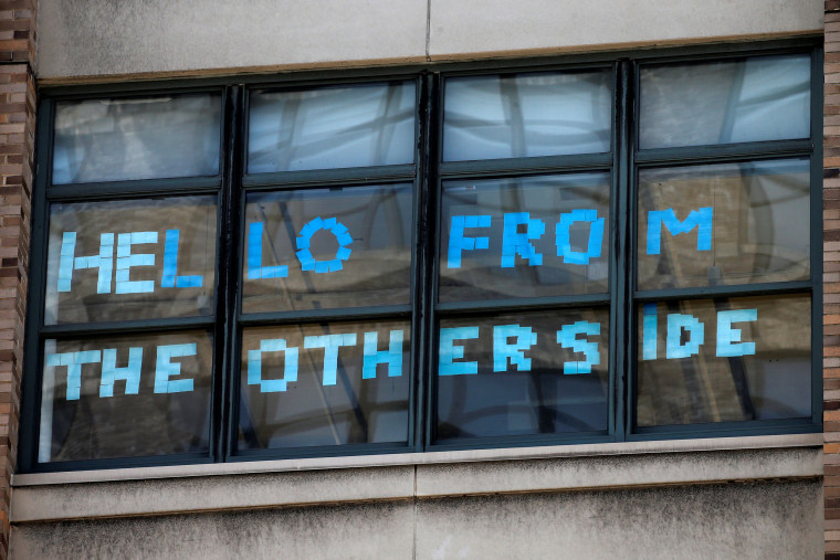 Image: A message created with Post-it notes are seen in windows of 200 Hudson street in lower Manhattan, New York