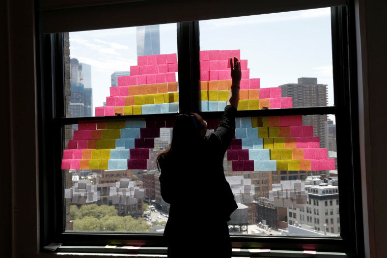 Image: Employee creates a rainbow image on a window with Post-it notes at the Horizon Media offices at 75 Varick Street in lower Manhattan, New York during \"Post-it note art war\"